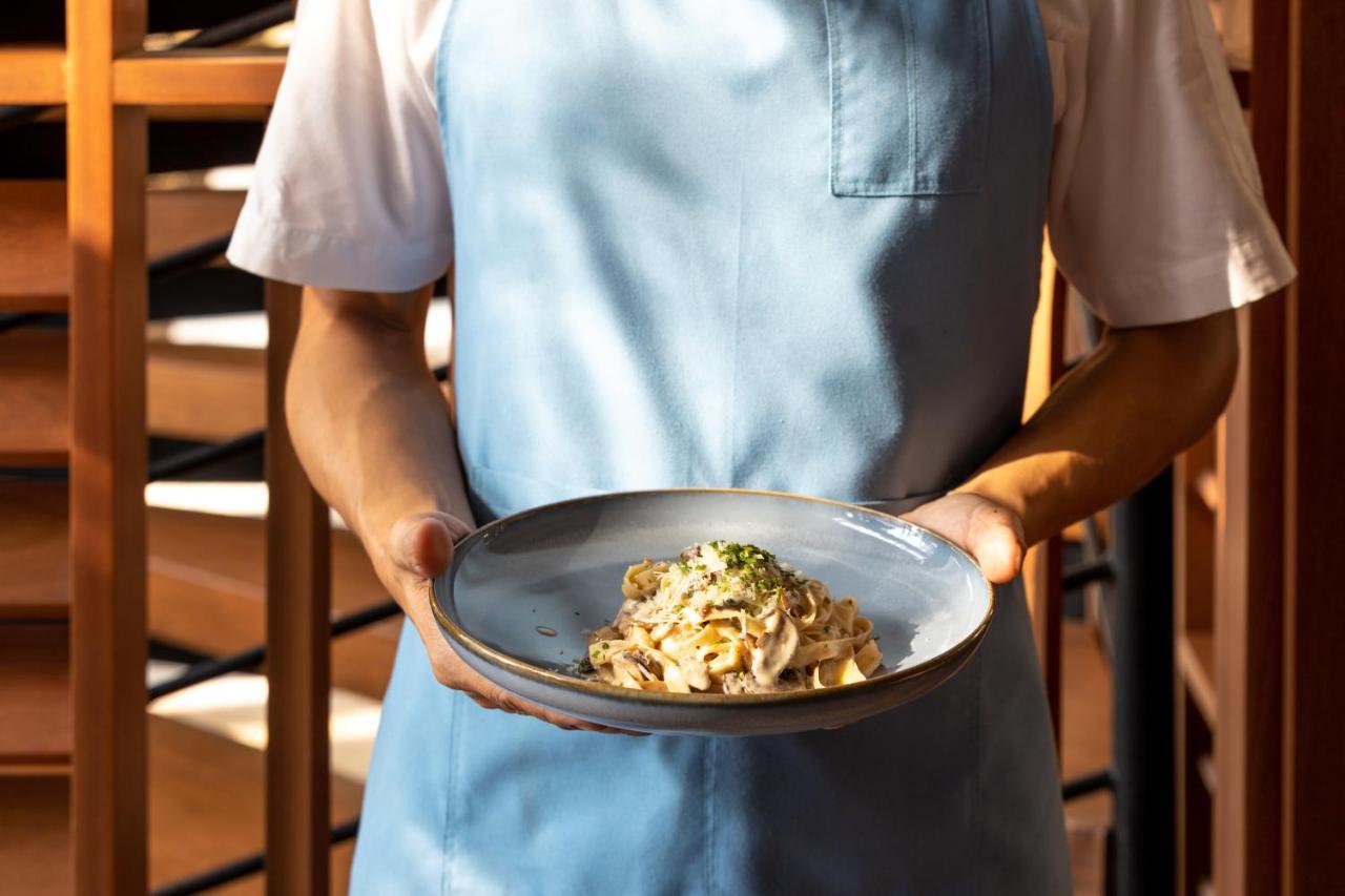 Outrigger Surin Beach Resort - Sha Extra Plus Kültér fotó A server holding a plate of pasta