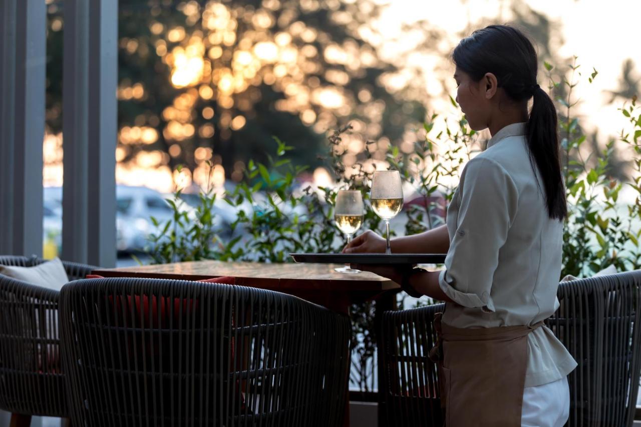 Outrigger Surin Beach Resort - Sha Extra Plus Kültér fotó A waitress clearing a table